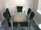 DINING table glass/chrome with 6 black suede chairs....